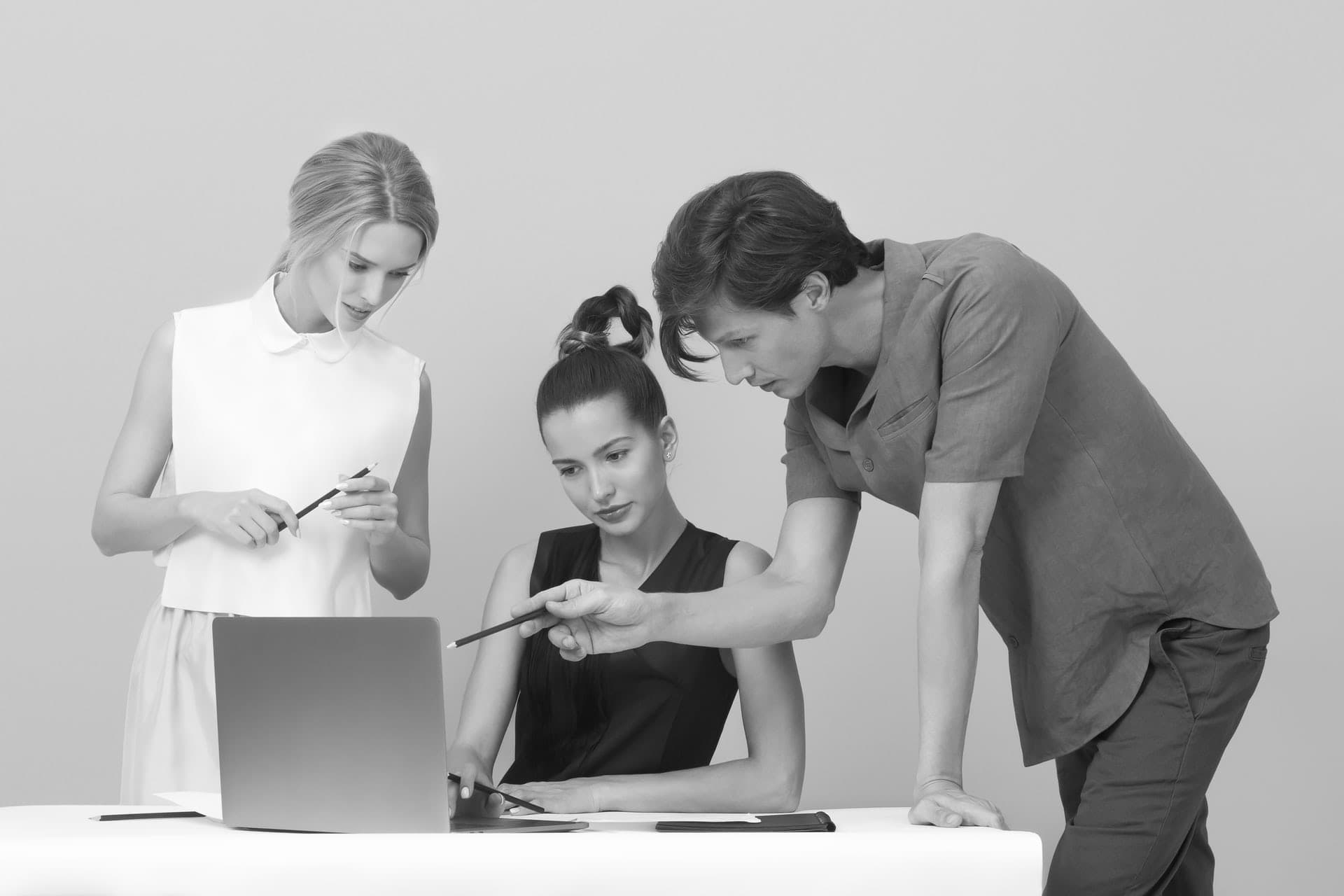 People discussing something around a computer